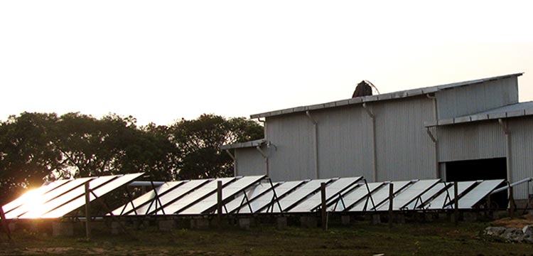 Array of solar panels outside a metal warehouse