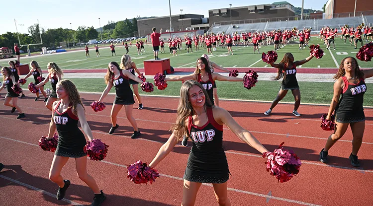 IUP cheerleaders perform in front of the marching band
