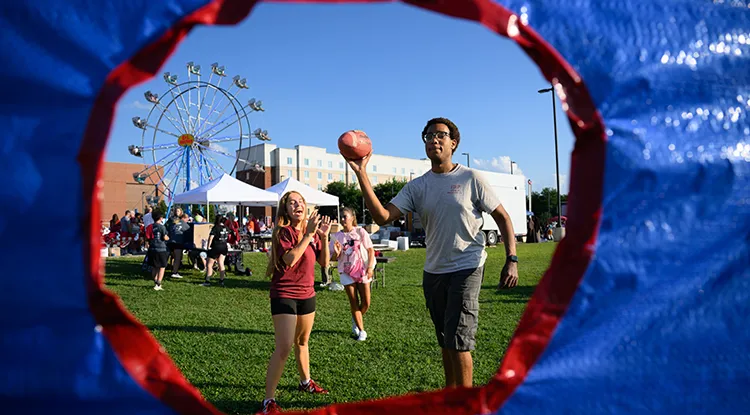 A photo of a student playing a football game shown through the back of the target