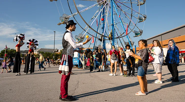 A juggler performing with a young onlooker