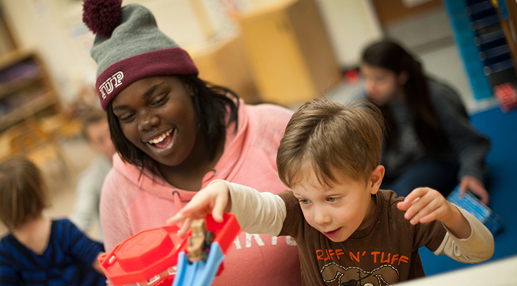 a student playing with a young child