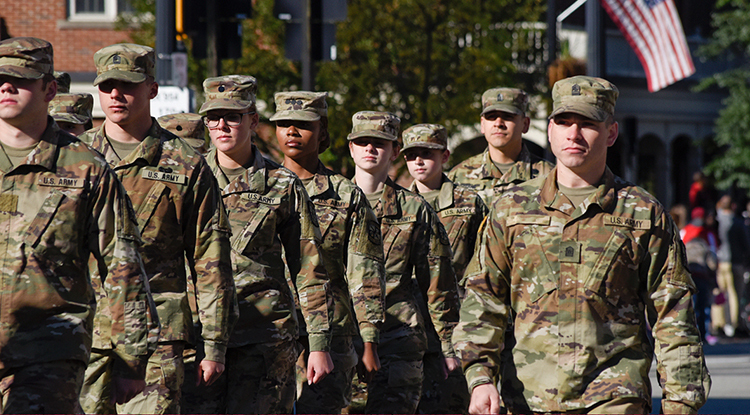 A group of miliary personnel in uniform standing and facing just left of the camera