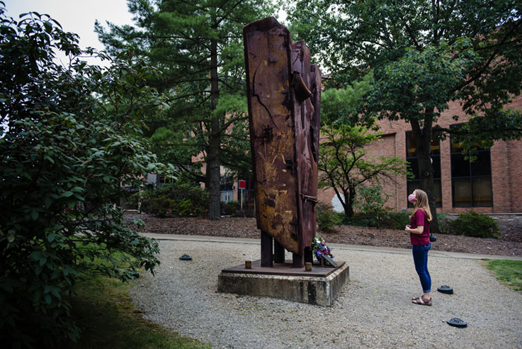 A student looking at the 9/11 memorial in the Oak Grove