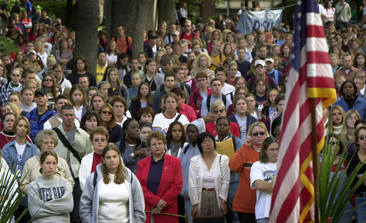 a crowed of people gathered together near a flag