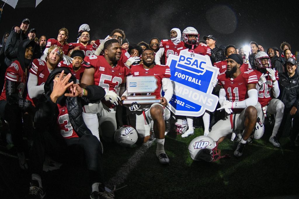 IUP football team holding the psac championship award