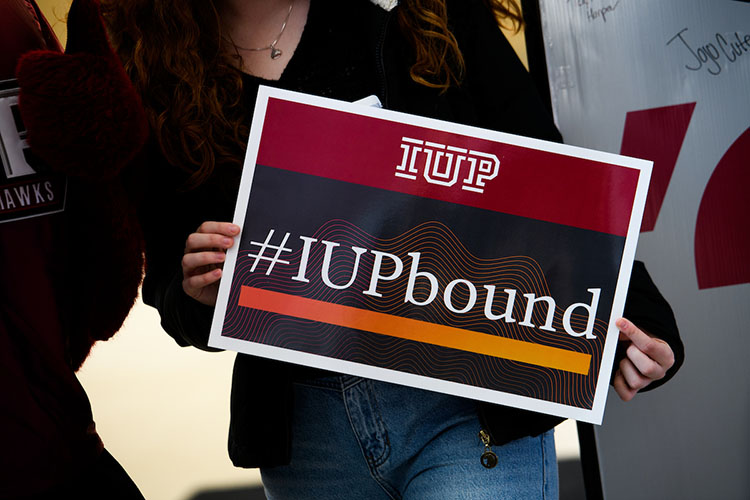 A new student holding an IUP bound sign.