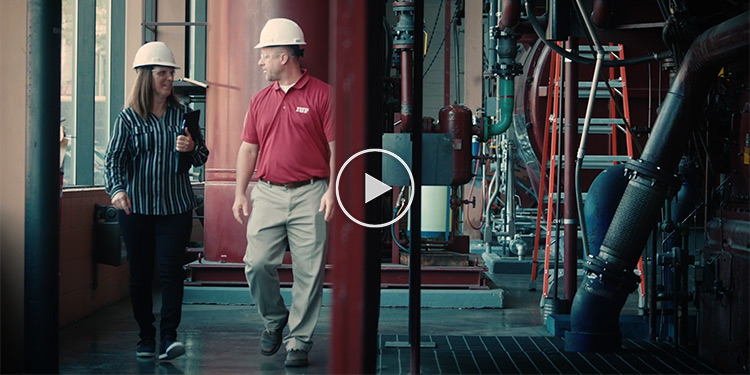 An expert from IUP's PA OSHA program walking through a facility talking with an employee