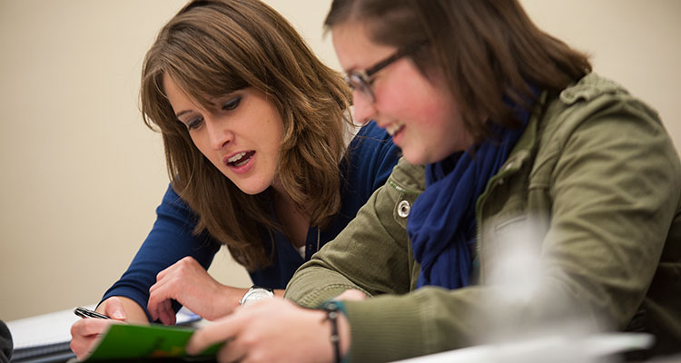 Two students work together on an assignment in an Adult and Community Education classroom.