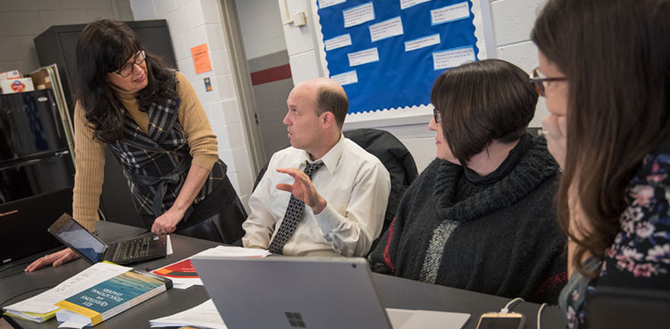 Students in an ALS cohort talk with a teacher
