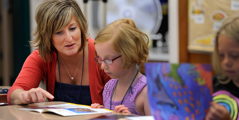 Student teacher talking with child 