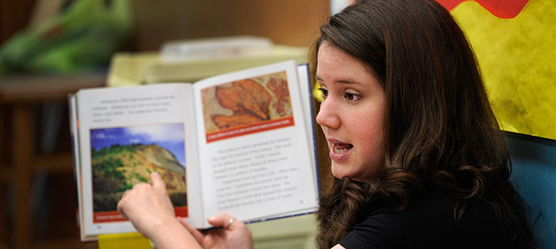 Education student reading a book to students 780