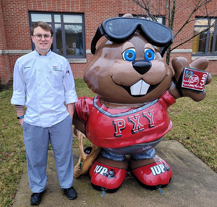 Essay scholarship winner Silas Gesser standing next to a statue of Punxsutawney Phil