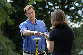 Dr. John Benhart works with a student using GPS equipment.