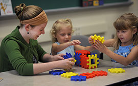 A student works with two children in the Child Study Center. A student works with two children in the Child Study Center.