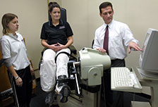 A professor and students use equipment in the Exercise Science Lab.
