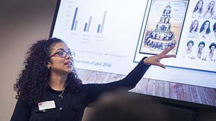 a woman presenting information projected on a white screen