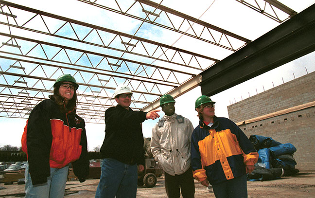 Four people inspect an industrial site