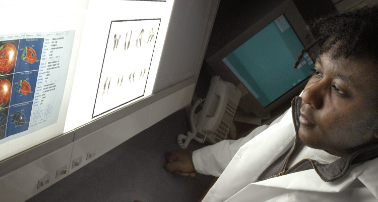 A student's face is seen observing a screen with medical images on it