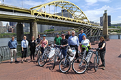 People with bikes by a bridge