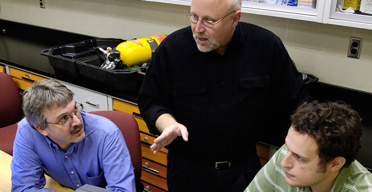 Graduate students in a classroom discussing jobs with a professor