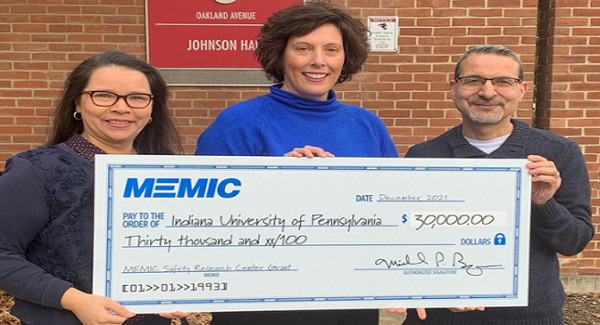 Memic staff receiving a check