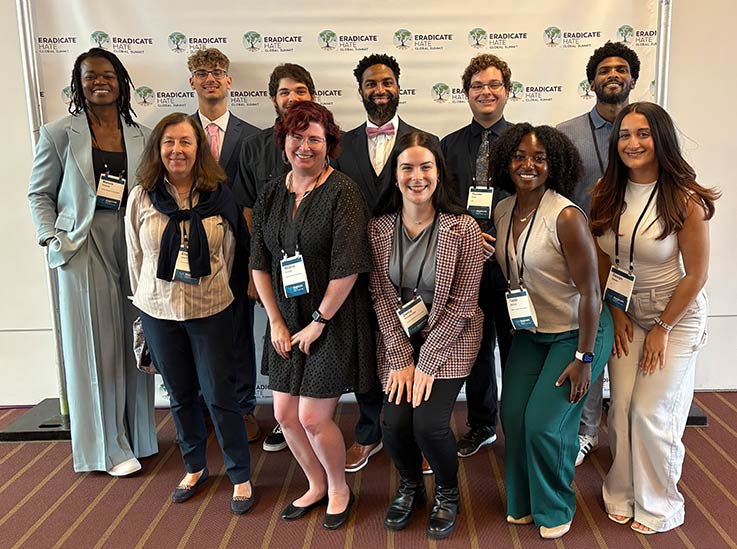 IUP administrators and students posing in front of a backdrop at the 2025 Eradicate Hate Global Summit