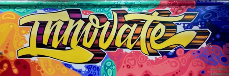 The word innovate spray painted on a wall in the style of graffiti.
