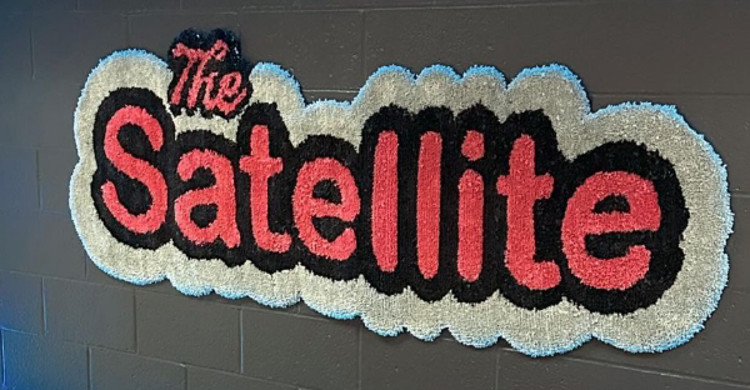 Image of carpeted logo that says The Satellite