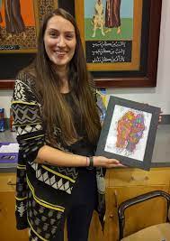 Emily Lasinsky holding a piece of her art work
