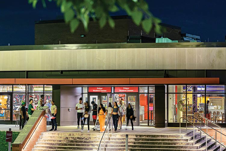 An evening view of students on the steps at the front entrance to the Folger Student Center 