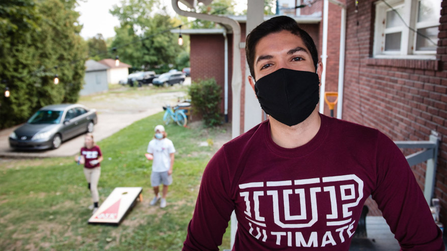 Student wearing mask on porch
