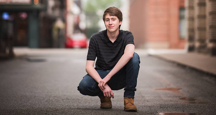a student kneeling and facing the camera
