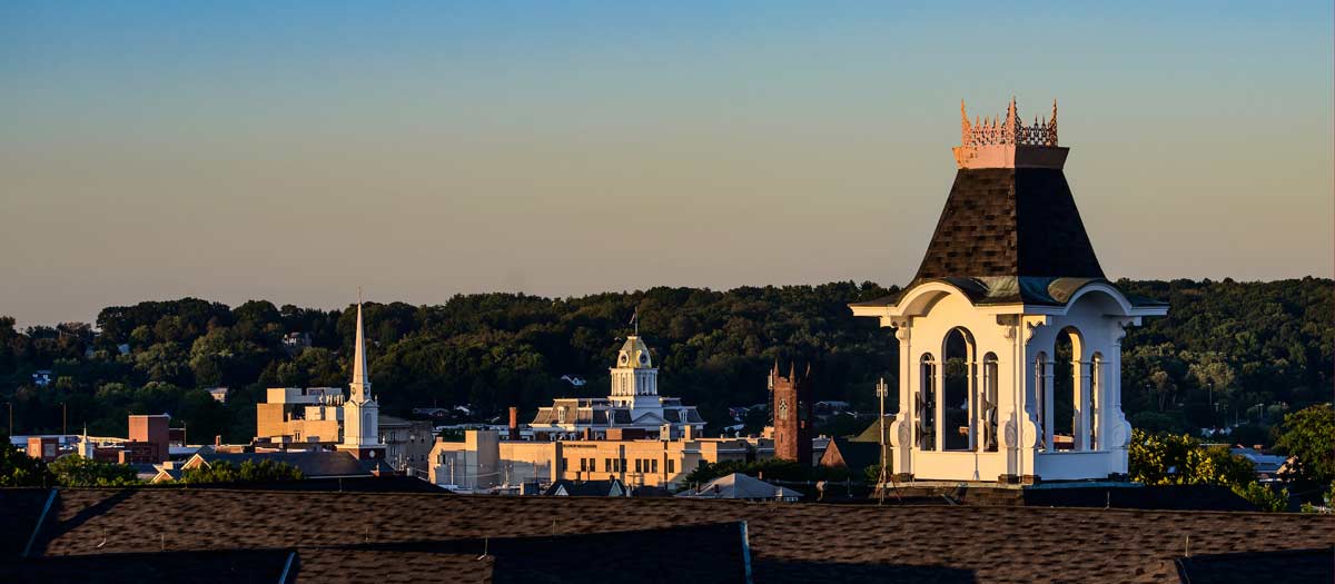 Photo of the Sutton Hall tower with a backdrop of the Indiana skyline at sundown