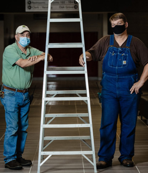 Barry Haldin, left, and Ed Buterbaugh after installing Meeting Owl technology inside College of Humanities and Social Sciences building classrooms Thousands of safety kits were assembled