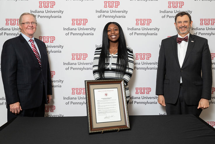 Sam Smith, chairman of the IUP Council of Trustees, Abigaelle Vertil, and President Michael Driscoll with the resolution Sam Smith, chairman of the IUP Council of Trustees, Abigaelle Vertil, and President Michael Driscoll with the resolution