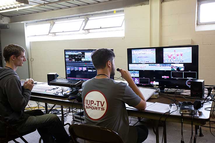 UP-TV Sports students Josh Nixon (left) working as technical director and Sean Seaman, as director, focus on producing a live production of IUP football. UP-TV Sports students Josh Nixon (left) working as technical director and Sean Seaman, as director, focus on producing a live production of IUP football.