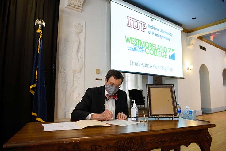 Michael Driscoll signing the dual admissions program agreement Michael Driscoll signing the dual admissions program agreement