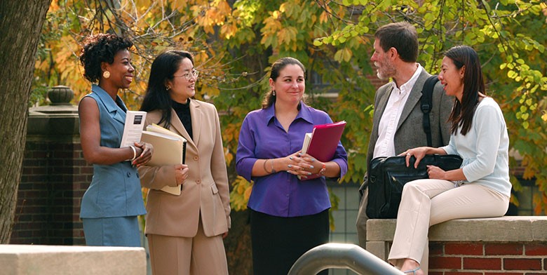 Graduate English students talking in the Oak Grove