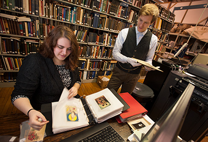 A history student works with historical documents with a staff member in a local museum
