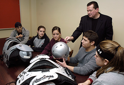 A professor helps students analyze athletic gear