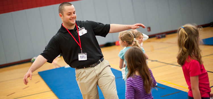 A student teaches children in a gym 