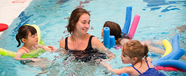 A student swimming with children 