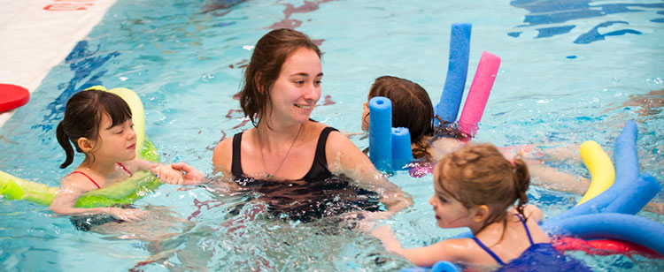 A student swimming with children