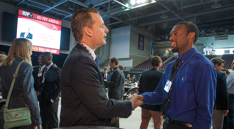 A student talks with a businessman during one of IUP's Business Days