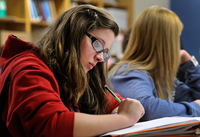 A student in class, working on a math paper