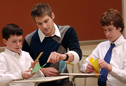 Students work with shapes with a student teacher