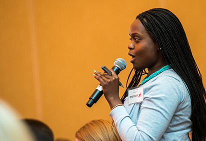 Mafei James speaking into a microphone