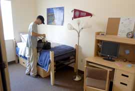 Student unpacking bag in residence hall room Student unpacking bag in residence hall room
