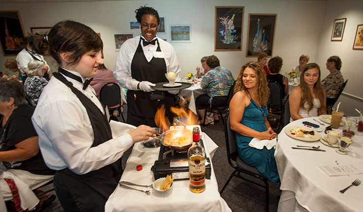 Culinary Arts students demonstrating fine dining tableside service