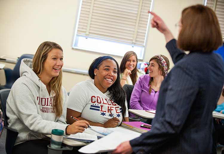 a female professor teaching students in a classroom